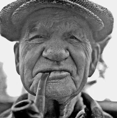 Old man in a hat smoking a pipe