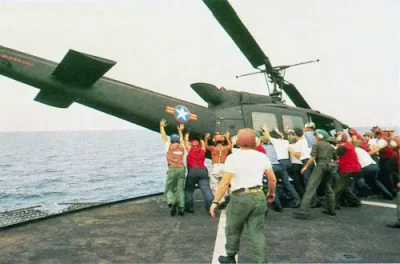 Vietnamese people trying to turn over a military helicopter